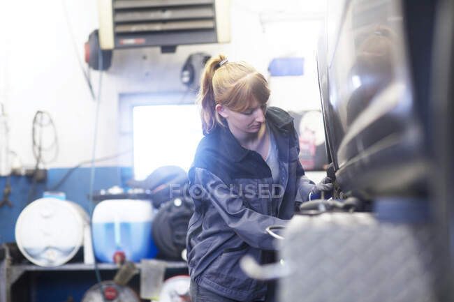 Mécanicien automobile femme travaillant dans le garage de réparation — Photo de stock