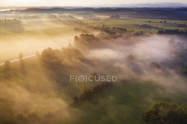 Alemania, Baviera, Geretsried, Vista aérea del campo envuelto en niebla al amanecer - foto de stock