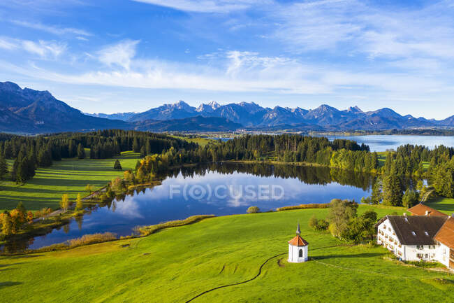 Germany, Bavaria, Halblech, Aerial view of small chapel, farmhouse and Hegratsrieder See lake in Tannheim Mountains — Stock Photo