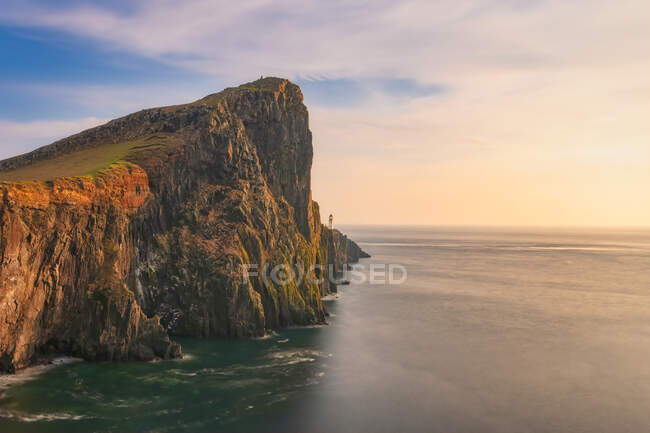 Neist Point Lighthouse by sea during sunset, Waterstein, Isle of Skye, Highlands, Scotland, UK — Stock Photo