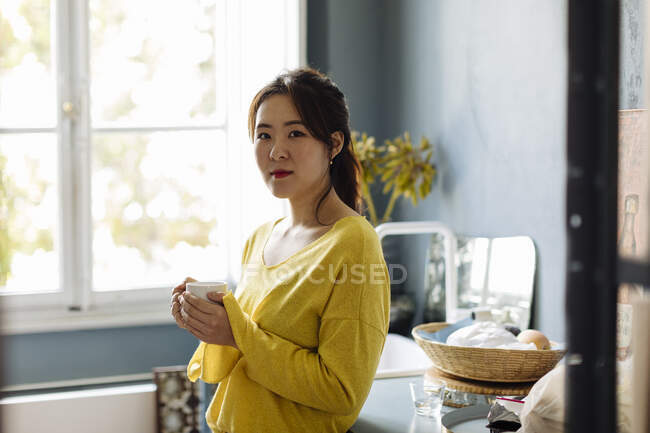 Woman drinking tea in office kitchenet — Stock Photo