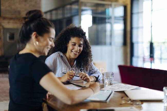 Due giovani imprenditrici che lavorano insieme al tavolo conferenze nell'ufficio loft — Foto stock