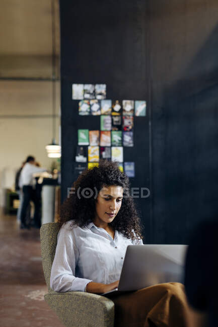 Молодая деловая женщина с ноутбуком в лофт-офисе — стоковое фото