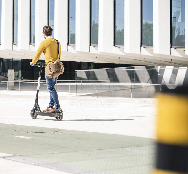 Young man riding e-scooter in the city — Stock Photo