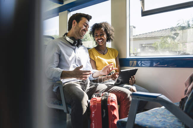 Glückliches junges Paar mit Tablet im Zug — Stockfoto