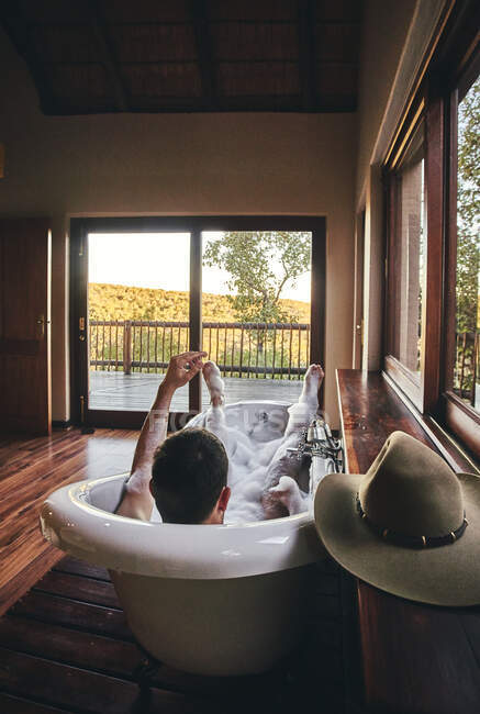 Homme prenant un bain relaxant dans la baignoire — Photo de stock