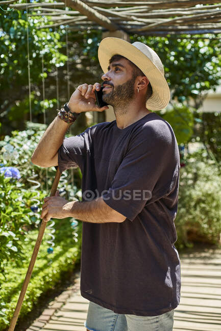 Uomo con scopa utilizzando il suo smartphone all'aperto — Foto stock