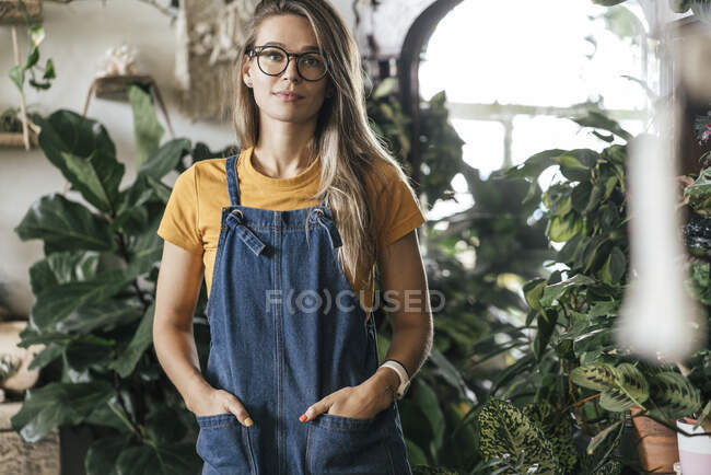 Портрет молодої жінки в маленькому садівничому магазині. — Stock Photo