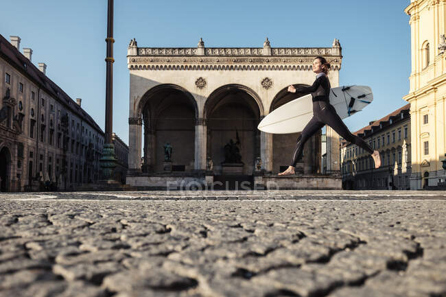Young woman with surfboard on the way to Eisbach, Munich, Germany — Stock Photo