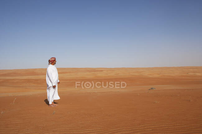 Beduino in abito nazionale in piedi nel deserto, vista posteriore, Wahiba Sands, Oman — Foto stock