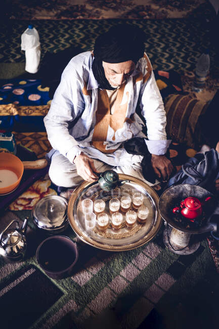 Un aîné du camp de réfugiés de Smara verse du thé dans des verres, Tindouf, Algérie — Photo de stock