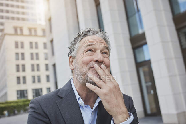 Портрет щасливого бізнесмена в місті, який дивиться вгору. — стокове фото