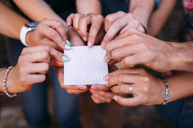 Gros plan d'amis tenant une carte blanche — Photo de stock