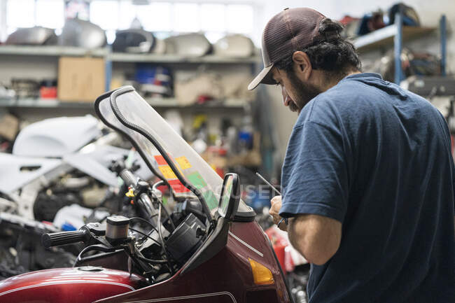 Mechanic in a repair garage repairing a motorcycle — Stock Photo