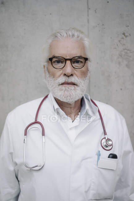 Retrato de un médico serio en una pared de hormigón - foto de stock