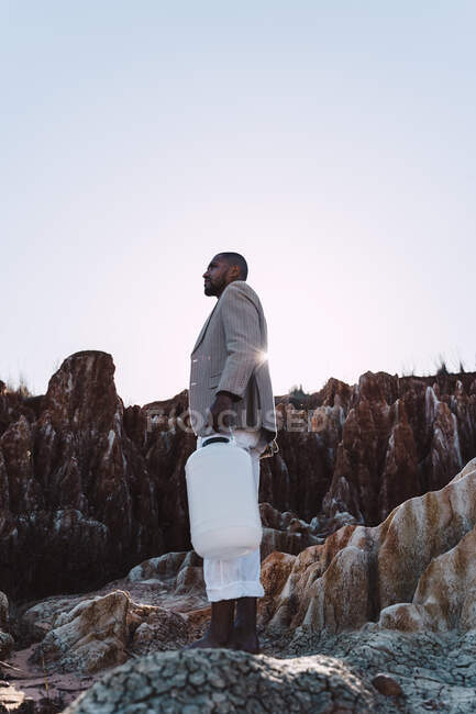 Junger Mann mit leerem Kanister auf der Suche nach Wasser in kargem Land — Stockfoto