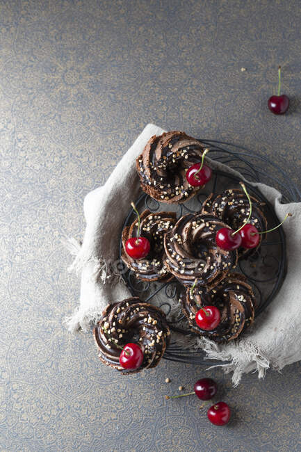 Cesta de tortas minigugelhupf alemanas con chocolate, frágiles y cerezas - foto de stock