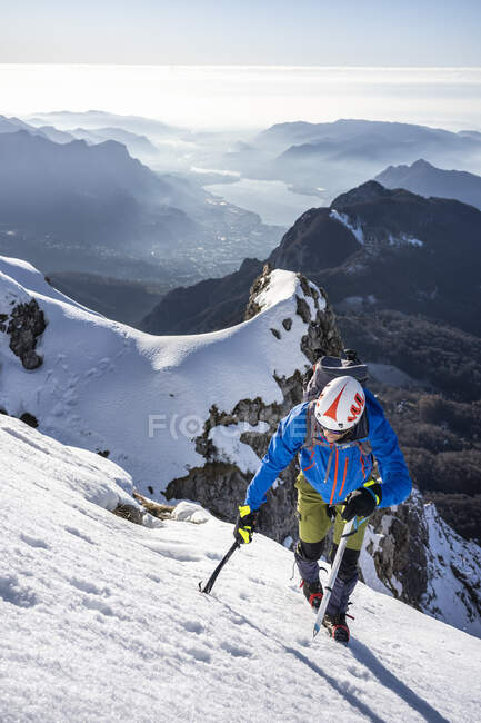 Alpinista che sale su una montagna innevata, Alpi Orobie, Lecco, Italia — Foto stock