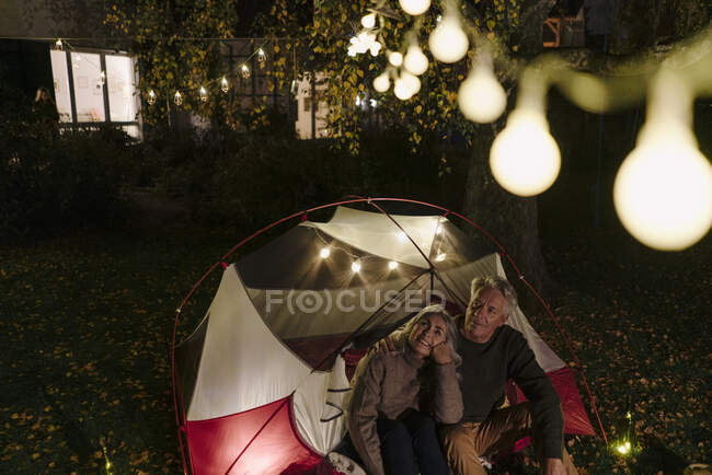 Couple sénior campant dans le jardin de leur maison la nuit — Photo de stock