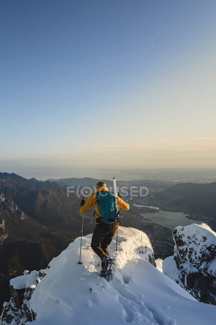 Mountaineer reaching the top of a snowy mountain enjoying the view, Lecco, Italy — Stock Photo