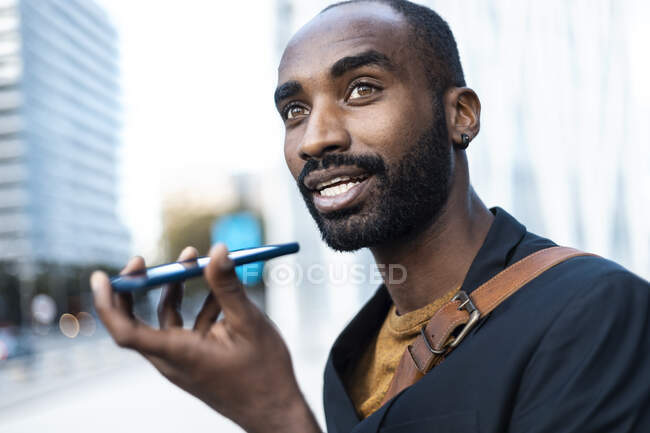 Portrait de jeune homme d'affaires utilisant un téléphone portable à l'extérieur — Photo de stock