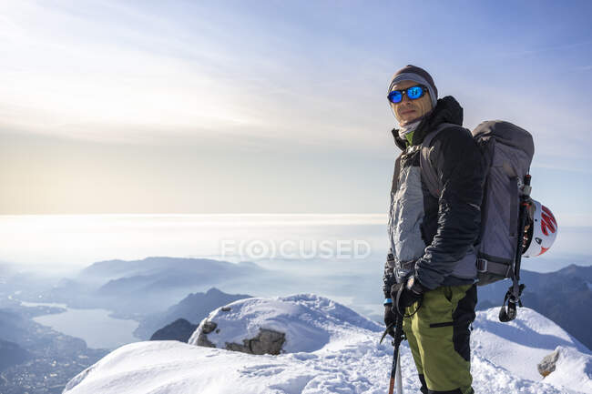 Portrait of an alpinist standing on snowy mountain peak, Orobie Alps, Lecco, Italy — Stock Photo