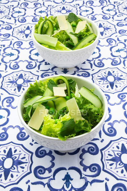 Pea and cucumber salad on patterned table — Stock Photo