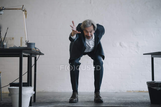 Homme d'affaires senior faisant de la gymnastique au bureau — Photo de stock