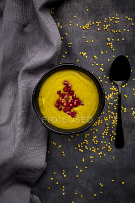 Bowl of vegan lentil soup with ginger, turmeric, coconut milk and pomegranate seeds — Stock Photo