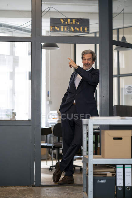 Portait of senior businessman standing at vip entrance in office — Stock Photo