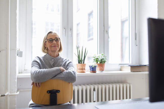 Reife Geschäftsfrau sitzt auf Stuhl im Büro — Stockfoto