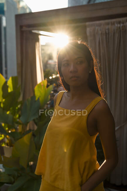 Portrait of woman standing on roof terrace at backlight — Stock Photo