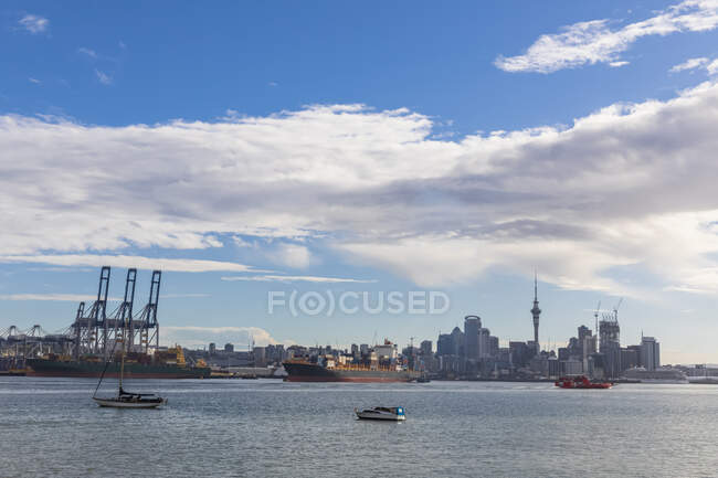 Edifici moderni e Devonport via mare contro il cielo nuvoloso ad Auckland, Nuova Zelanda — Foto stock