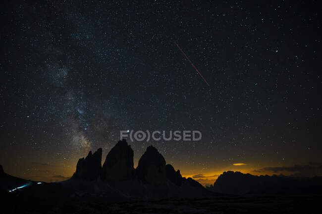 Vista panorâmica da silhueta Tre Cime Di Lavaredo contra o campo estelar à noite, Itália — Fotografia de Stock