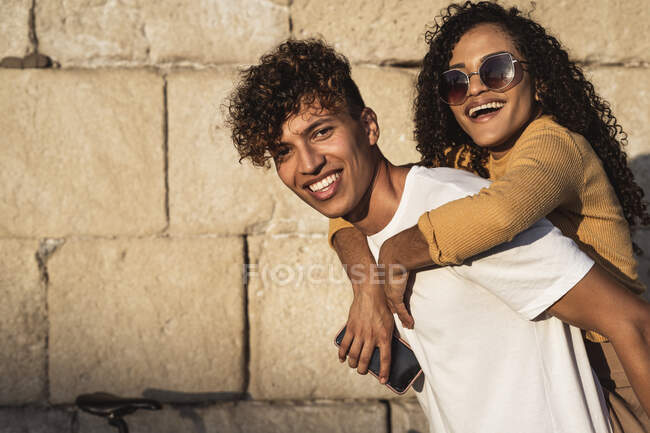 Young couple at stone wall — Stock Photo