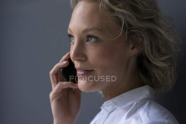 Portrait de jeune femme d'affaires souriante au téléphone — Photo de stock