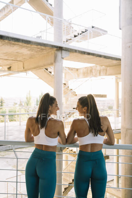 Rear view of two happy twin sisters relaxing after doing sports — Stock Photo