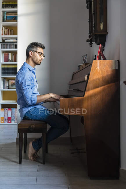Pieds nus jeune homme jouant du piano à la maison — Photo de stock