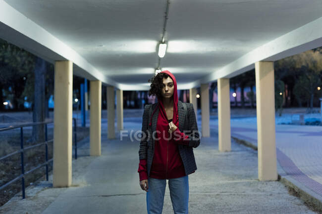 Retrato de una mujer joven con chaqueta con capucha roja en la noche - foto de stock