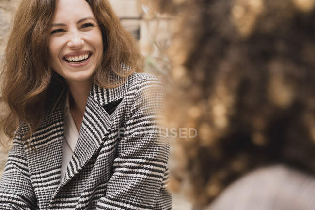 Deux femmes heureuses se rencontrent et parlent à l'extérieur dans la ville — Photo de stock