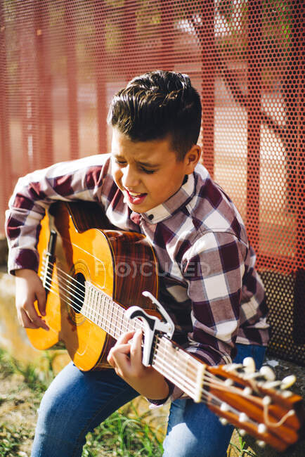 Gypsy boy playing guitar outdoors — Stock Photo