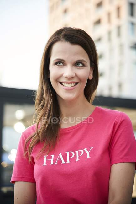 Ritratto di donna felice che indossa una t-shirt rosa in città — Foto stock