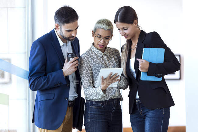 Gente de negocios compartiendo tableta en oficina - foto de stock