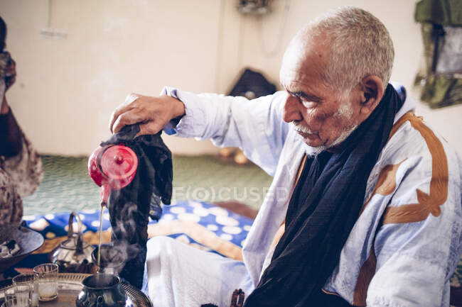 Старший в лагере беженцев Смара, готовит чай, Тиндуф, Алжир — стоковое фото