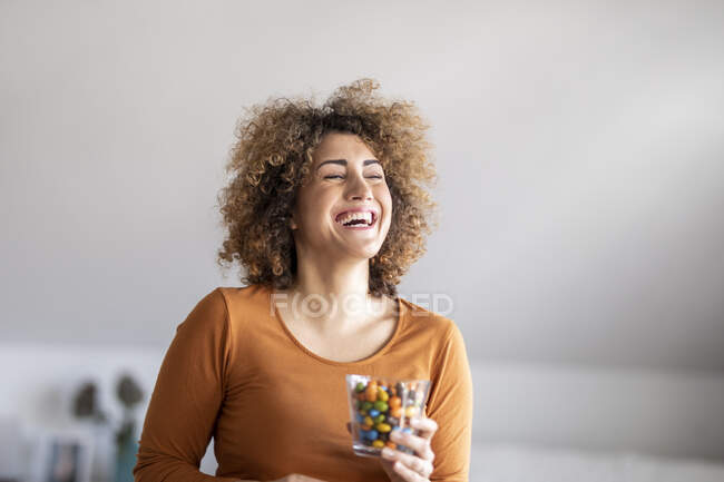 Smiling mid adult woman eating a cookie — Stock Photo