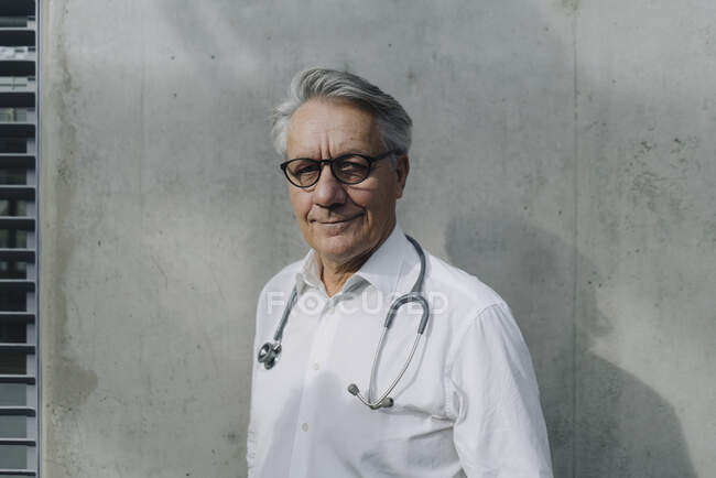 Retrato de un médico de confianza en una pared de hormigón - foto de stock