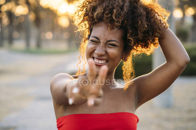 Joven mujer feliz expresando gesto V con los dedos - foto de stock