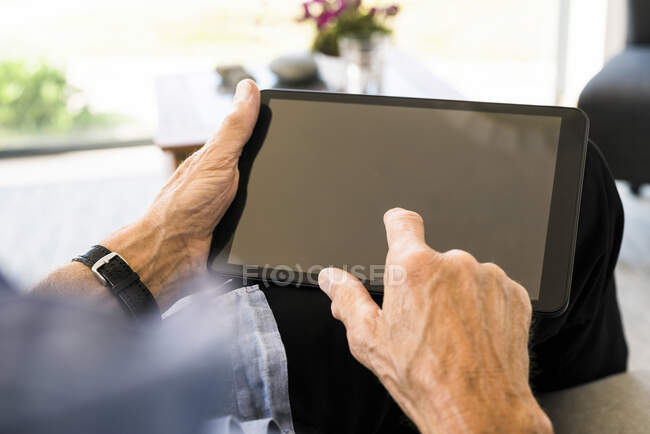 Close-up of senior man using tablet at home — Stock Photo