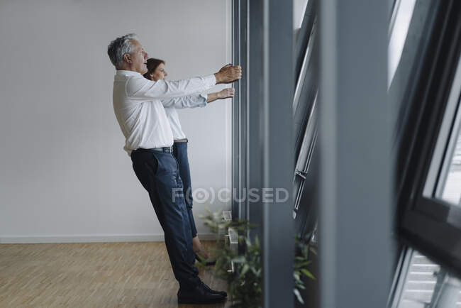 Empresário sênior e empresária segurando viga no escritório — Fotografia de Stock