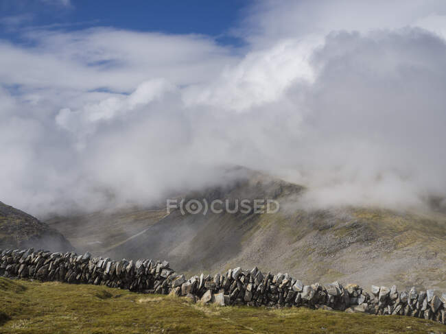 Каменная стена на горе против облачного неба, Шотландия, Великобритания — стоковое фото